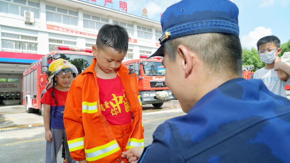 孩子們穿上消防員滅火防護服。姚遙攝