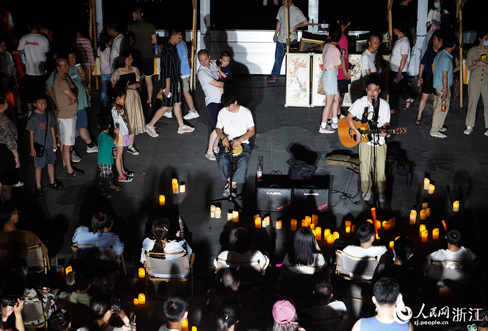 在寧波老外灘集市上，街頭藝人的現場演唱吸引了許多市民駐足。人民網 章勇濤攝