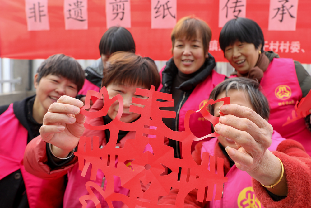 婦女將一張張紅紙剪成各種圖案。白羽攝