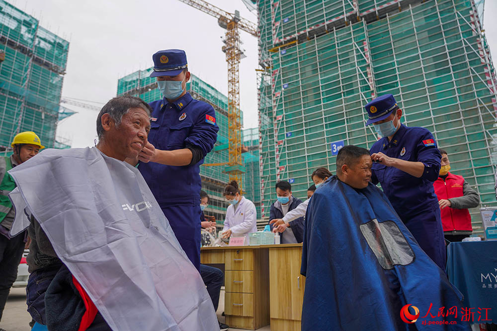 3月1日，在杭州市拱墅區石橋街道，來自消防救援隊伍的志愿者在為工人理發。人民網 章勇濤攝