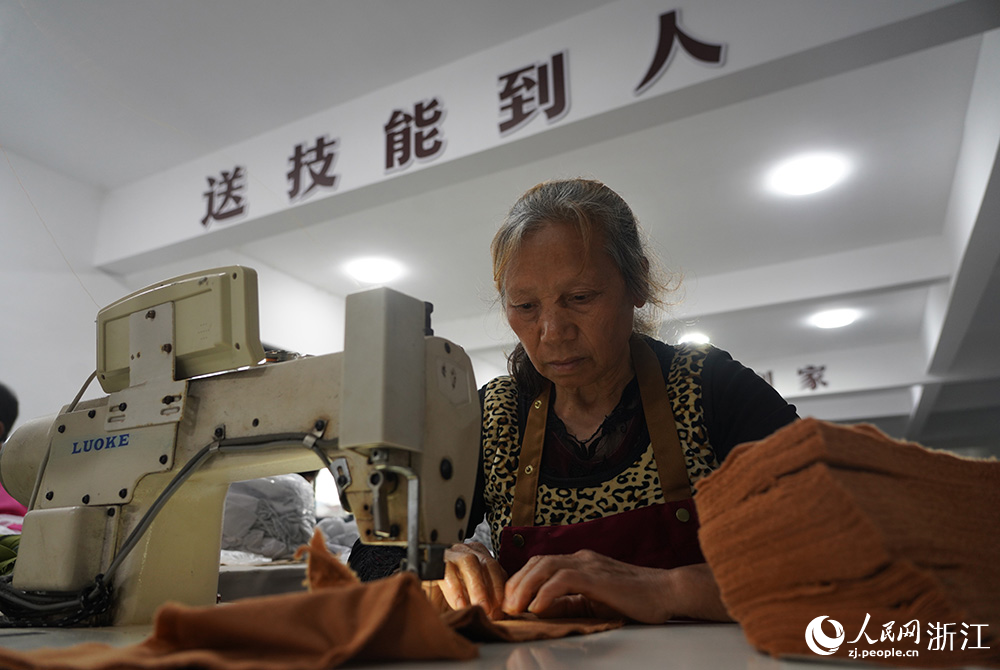 在浙江省臺州市仙居縣田市鎮水閣村“共富工坊”，工人們忙著趕制服裝。人民網 章勇濤攝