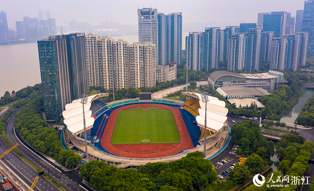 從空中俯瞰浙江省杭州市錢塘江畔的上城區體育中心，鮮艷的紅藍塑膠田徑跑道與鋪設了大片綠色草皮的足球場相映成景。人民網 章勇濤攝