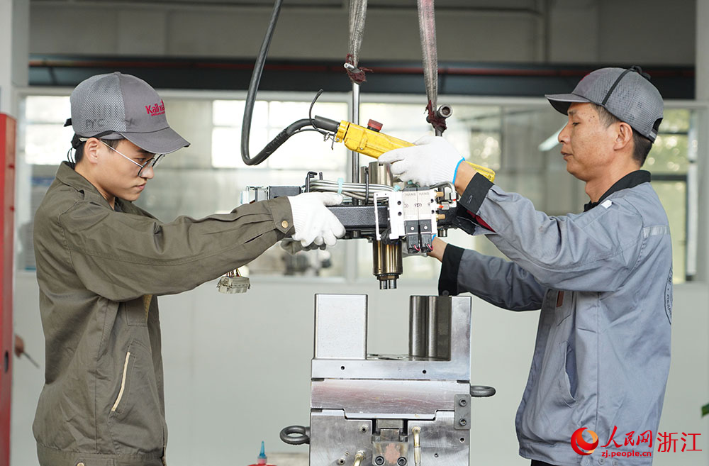 在臺州科技職業學院凱華模具產業學院，學生（左）在吊裝模具。人民網 章勇濤攝