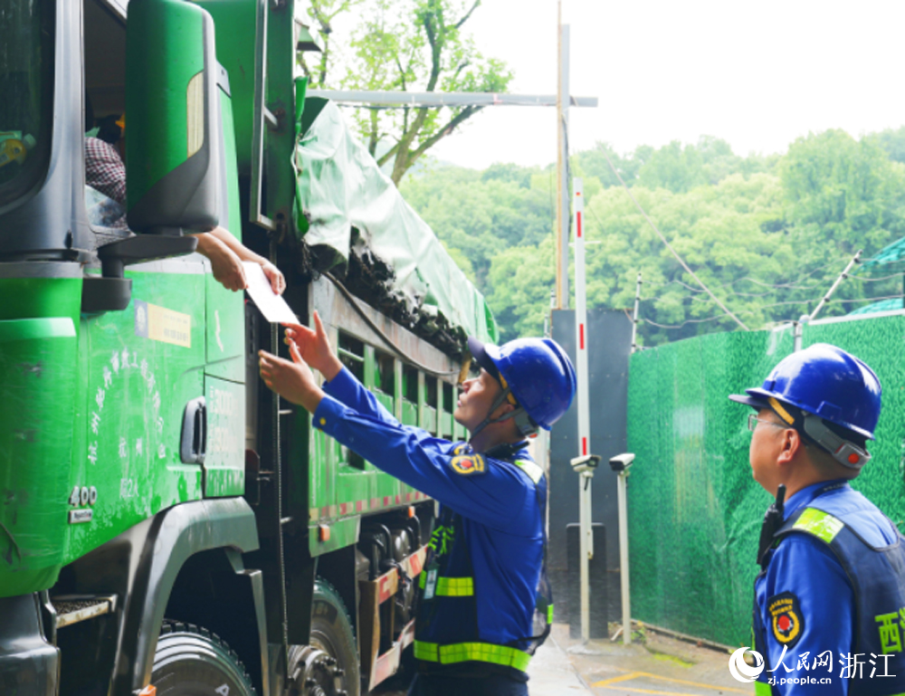 杭州西湖風景名勝區綜合行政執法隊隊員檢查渣土車是否辦理準運證。人民網 劉欣蔚攝