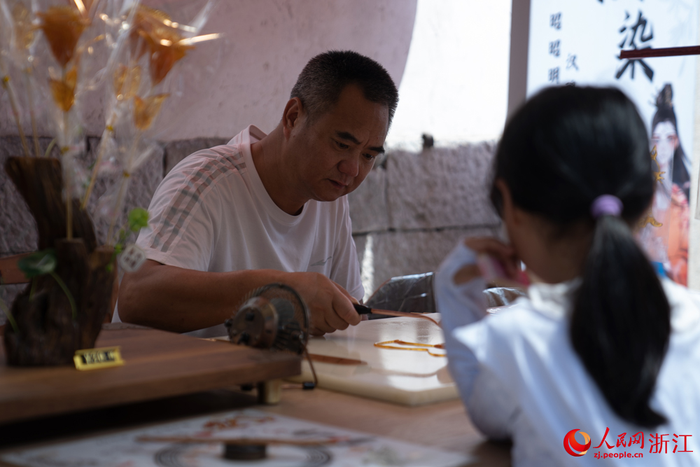 5月26日，在浙江省嘉興市月河街的一家店鋪內，師傅正在為客人制作糖人。人民網 陳陸洵攝