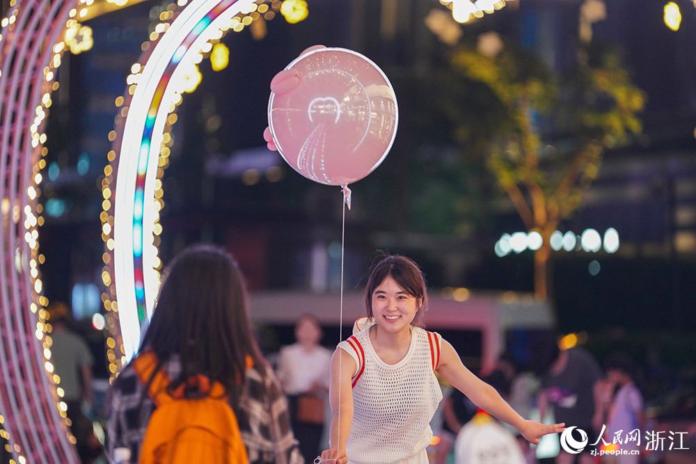 5月25日，杭州武林夜市燈光秀吸引游客駐足，拍照打卡留念。人民網 章勇濤攝