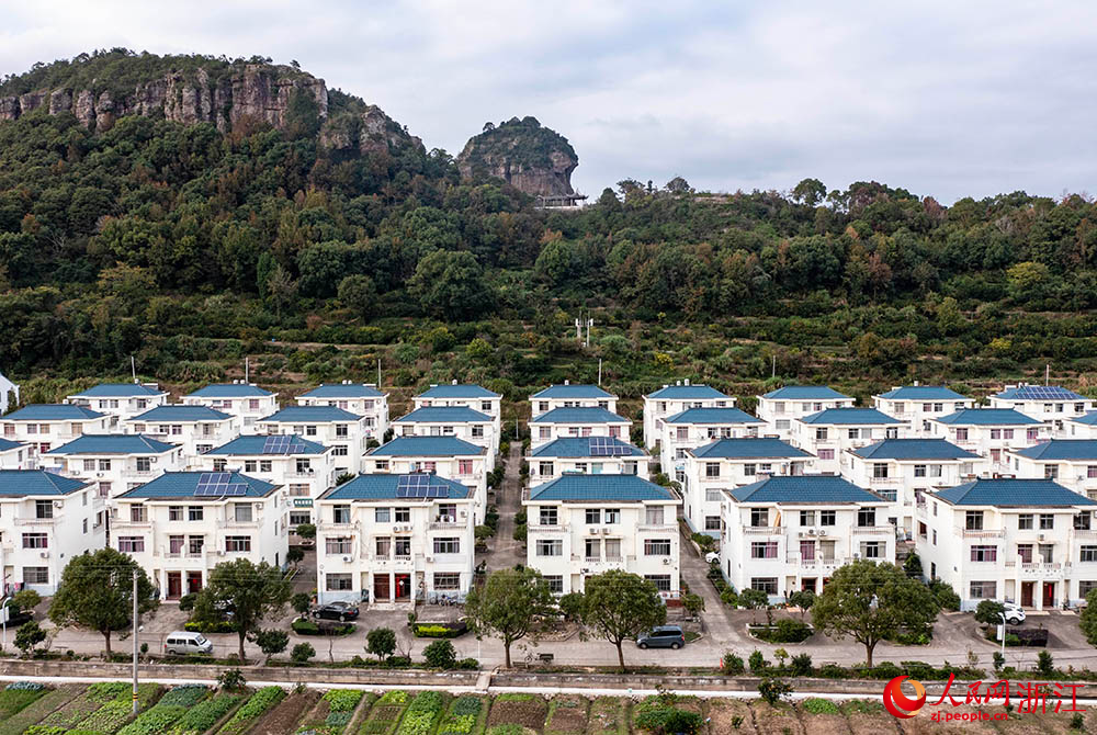 空中俯瞰浙江省臨海市桃渚鎮(zhèn)石柱下村，一排排民宿整齊排列，坐落在青山綠水間，愜意的田園風(fēng)光盡顯悠然之趣。人民網(wǎng) 章勇濤攝